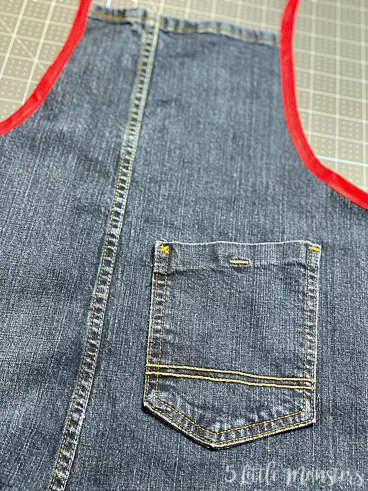 This super cute denim apron was made using an old pair of jeans and some recycled crafts supplies - easy peasy and totally useful!