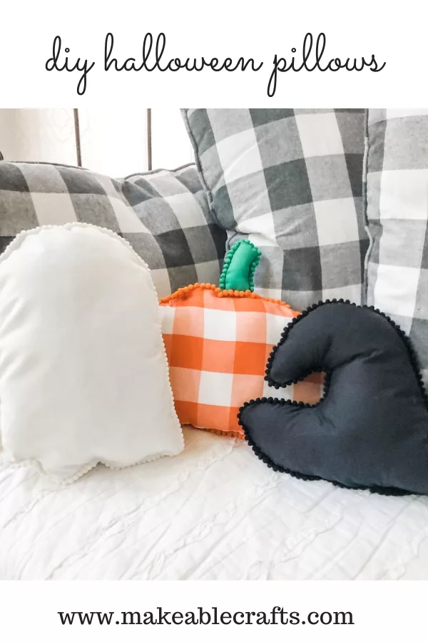 three DIY Halloween Pillows - a white ghost, a black bat and an orange buffalo check pumpkin on a couch