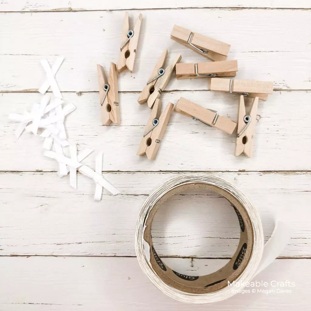 Mini clothespins, tiny bows and adhesvie to be used on a DIY fall home decor decorative wall sign